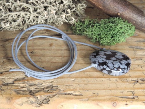 Obsydian śnieżny na szarym, okrągłym rzemieniu - kamień naturalny, przewiercony. Długość rzemyka regulowana za pomocą przeciąganych supełków.