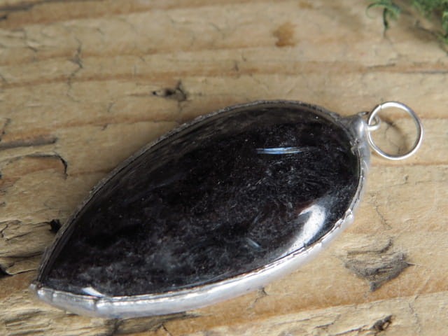 Wisior z antofyllitu oprawionego w miedź i cynę. Ten unikalny wisior to połączenie naturalnego piękna i rękodzielniczego kunsztu. Antofyllit to rzadki minerał należący do grupy amfiboli.