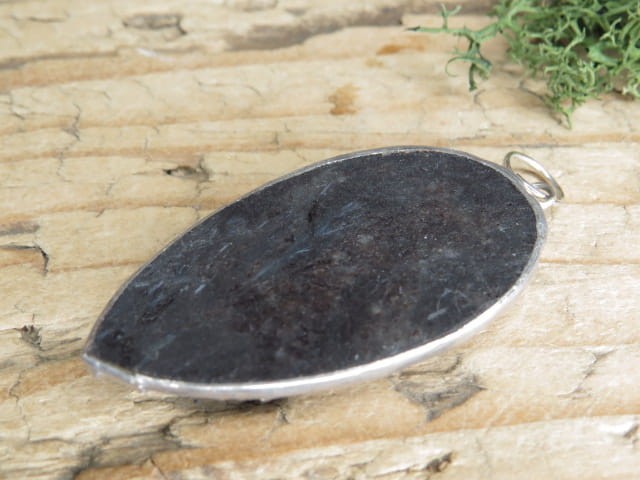 Wisior z antofyllitu oprawionego w miedź i cynę. Ten unikalny wisior to połączenie naturalnego piękna i rękodzielniczego kunsztu. Antofyllit to rzadki minerał należący do grupy amfiboli.