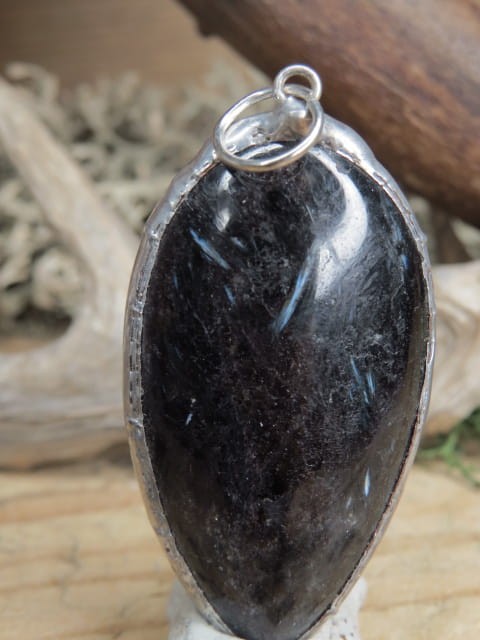 Wisior z antofyllitu oprawionego w miedź i cynę. Ten unikalny wisior to połączenie naturalnego piękna i rękodzielniczego kunsztu. Antofyllit to rzadki minerał należący do grupy amfiboli.