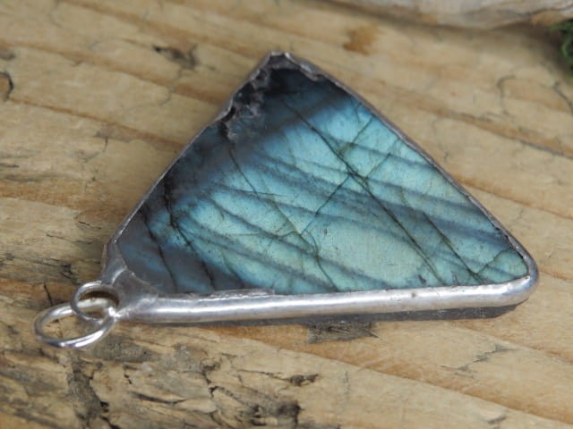 Wisior z labradorytu. Wielkość kamienia: 3,7 x 4 x 0,5cm Labradoryt – kamień intuicji, ochrony i przemiany. Labradoryt to wyjątkowy kamień o tajemniczym, opalizującym blasku – od wieków uważany za kamień magii, intuicji i duchowej przemiany.