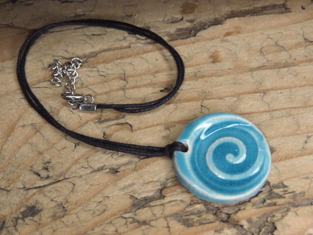 Niebieski wisior ceramiczny z motywem spirali. Ręcznie wykonany w Kuźni Alchemicznej, zawieszony na bawełnianym sznurku z zapięciem.