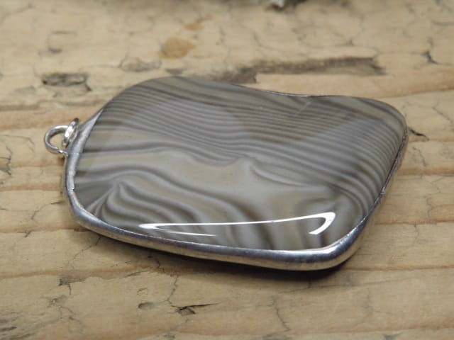 Wisior z krzemienia pasiastego w oprawie z miedzi i cyny – kamień optymizmu i siły Unikalny wisior wykonany z naturalnego krzemienia pasiastego, ręcznie oprawionego w miedź i cynę.