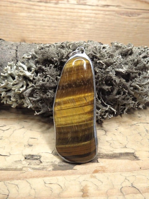 Wisior z tygrysiego oka – kamienia odwagi, ochrony i bogactwa. Ręcznie oprawiony w miedź i cynę. Naturalna biżuteria przyciągająca dobrobyt.