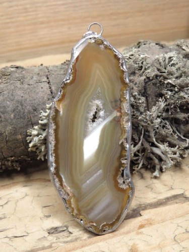 Wisior z polerowanego plastra agatu – kamienia ochrony ogniska domowego. Ręcznie oprawiony w miedź i cynę. Amulet spokoju, harmonii i stabilności.