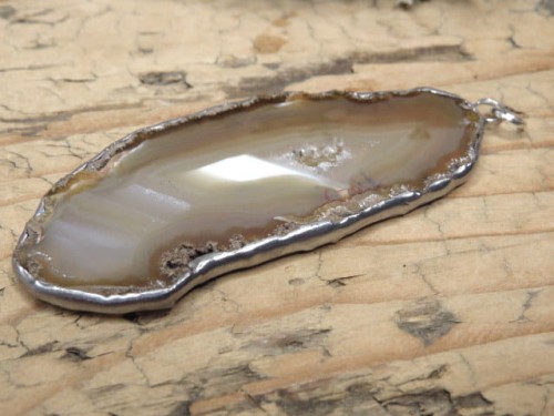 Wisior z polerowanego plastra agatu – kamienia ochrony ogniska domowego. Ręcznie oprawiony w miedź i cynę. Amulet spokoju, harmonii i stabilności.