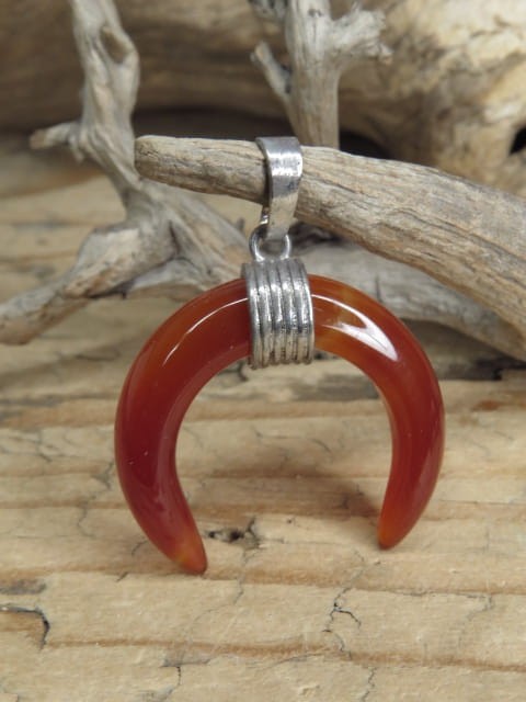 Wisior w kształcie lunuli wykonany z agatu pomarańczowego – kamienia witalności, odwagi i równowagi emocjonalnej.