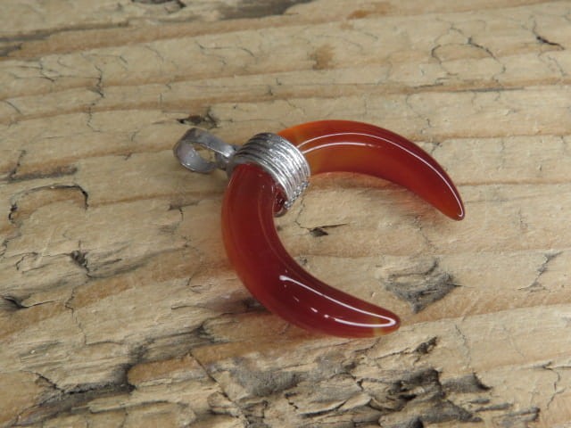 Wisior w kształcie lunuli wykonany z agatu pomarańczowego – kamienia witalności, odwagi i równowagi emocjonalnej.