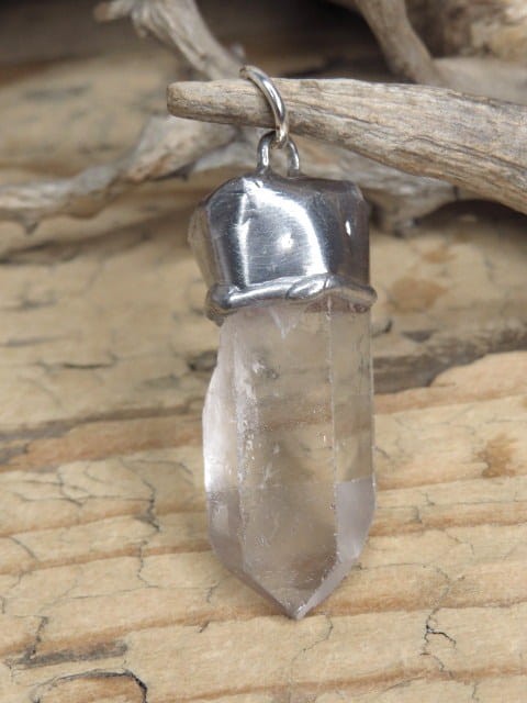 Amulet z naturalnego kryształu górskiego z kolekcji GeoDesign. Surowy kryształ w oprawie z miedzi i cyny. Unikatowy wisior z właściwościami energetycznymi – ręcznie wykonany.