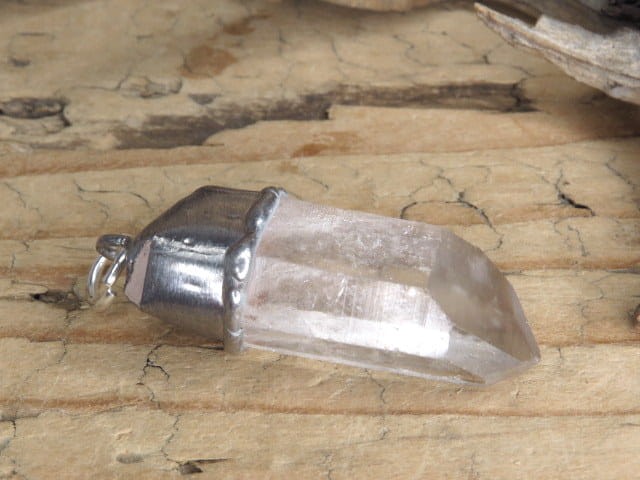 Amulet z naturalnego kryształu górskiego z kolekcji GeoDesign. Surowy kryształ w oprawie z miedzi i cyny. Unikatowy wisior z właściwościami energetycznymi – ręcznie wykonany.