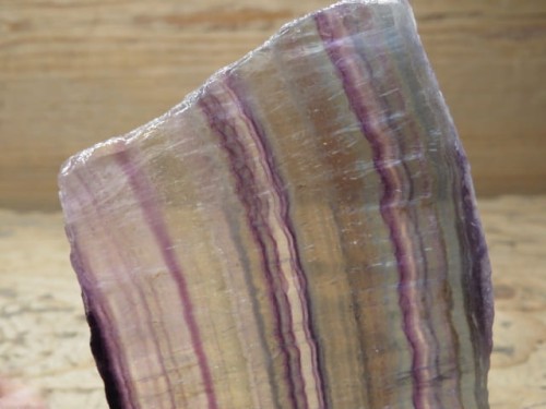 Wyjątkowy okaz tęczowego fluorytu w formie płytki, starannie wypolerowanej z obu stron. Kamień zachwyca naturalnym układem barw – odcienie fioletu, zieleni i błękitu układają się w subtelne pasy, tworząc niepowtarzalną kompozycję.