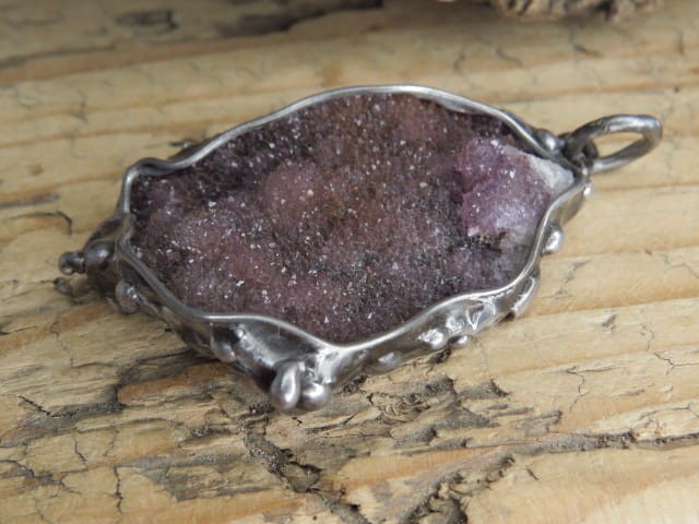 Wisiorek z surowego ametystu oprawionego w miedź i cynę. Ten wyjątkowy wisiorek łączy w sobie naturalne piękno ametystu i artystyczne rzemiosło.