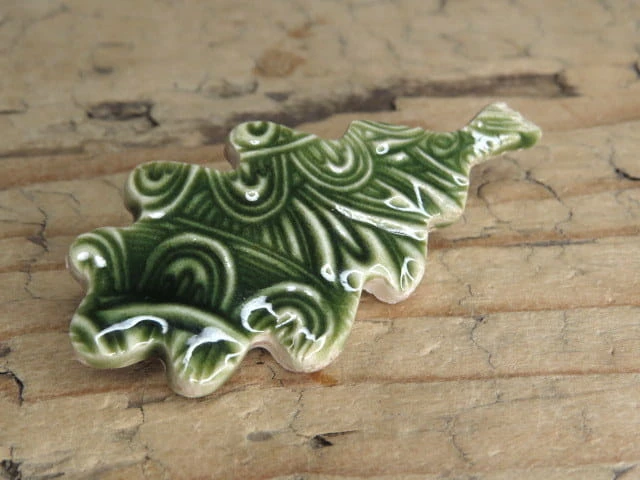 Ręcznie wykonana ceramiczna broszka w kształcie liścia z Pracowni Ceramiki Kuźni Alchemicznej. Pokryta szkliwem w odcieniach zieleni.