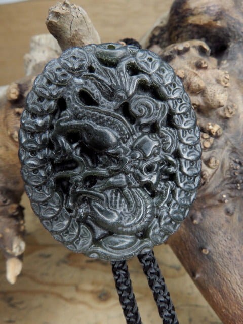 Eleganckie bolo wykonane z naturalnego jadeitu, ozdobione misternym wizerunkiem chińskiego smoka – symbolu siły, ochrony i pomyślności.