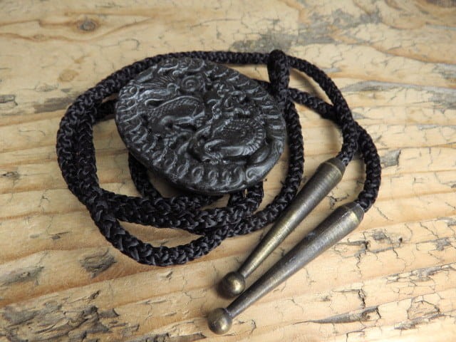 Eleganckie bolo wykonane z naturalnego jadeitu, ozdobione misternym wizerunkiem chińskiego smoka – symbolu siły, ochrony i pomyślności.