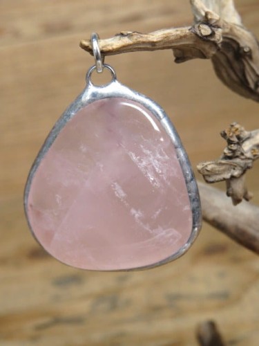 Wisior z polerowanego kwarcu różowego w miedzi i cynie.