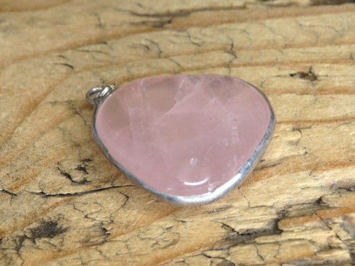 Wisior z polerowanego kwarcu różowego w miedzi i cynie.