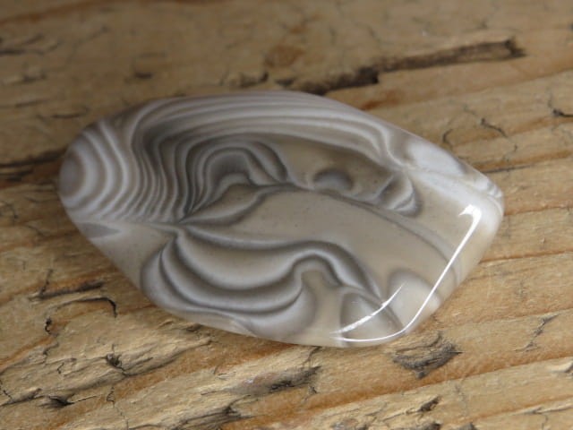 Polerowany krzemień pasiasty z Polski – naturalny kamień o wyraźnych ciemnych i jasnych pasmach. Unikatowy okaz kolekcjonerski i ozdobny.