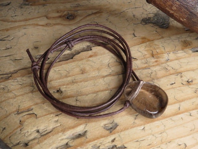 Wisior amulet z naturalnego kwarcu dymnego na brązowym, regulowanym rzemyku.