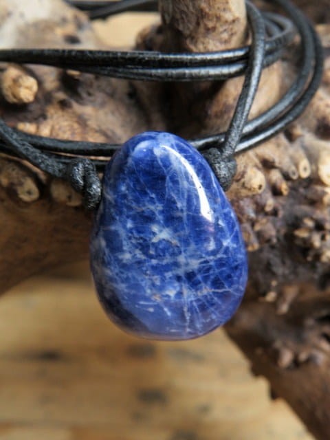 Wisior z naturalnego sodalitu na czarnym, regulowanym rzemieniu.