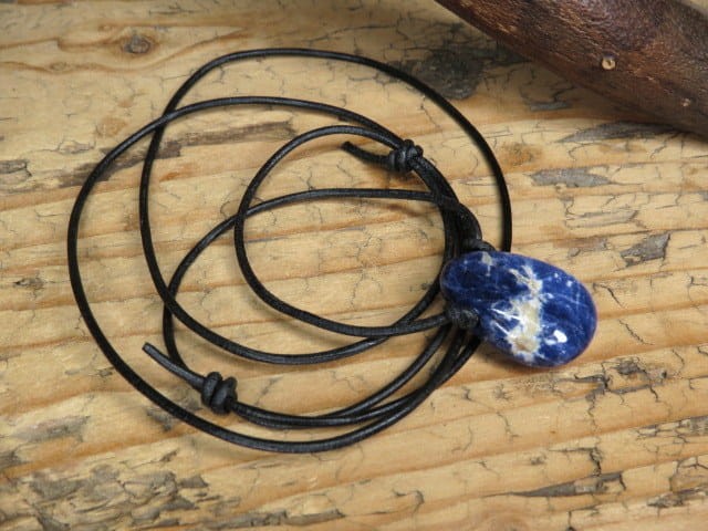 Wisior z naturalnego sodalitu na czarnym, regulowanym rzemieniu.