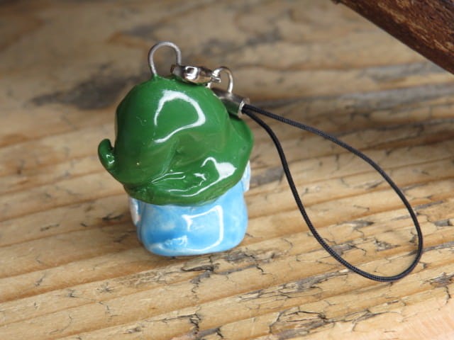 Ręcznie robiony skrzat z ceramiki – zawieszka na choinkę lub figurka stojąca. Zielona czapka, niebieskie ubranko, siwa broda. Świąteczny klimat. Kolorowy krasnal – ozdoba i prezent handmade.