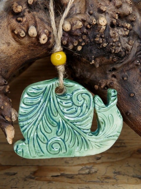 Ceramiczna zawieszka ślimak w zielonym szkliwie z ornamentem roślinnym