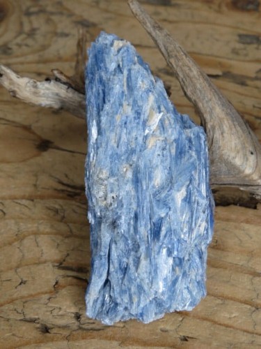 Dysten (cyjanit) z Brazylii – naturalny, nieobrobiony minerał o intensywnej niebieskiej barwie, wykazujący fluorescencję UV.