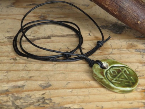 Ceramiczny wisior z symbolem Czarnoboga w zielono-brązowym szkliwie na czarnym regulowanym rzemieniu