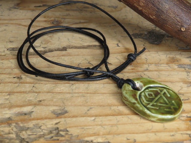 Ceramiczny wisior z symbolem Czarnoboga w zielono-brązowym szkliwie na czarnym regulowanym rzemieniu