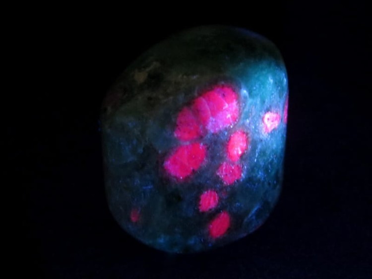 Okaz fuchsytu z rubinami - kamień wypolerowany, luminescencja UV