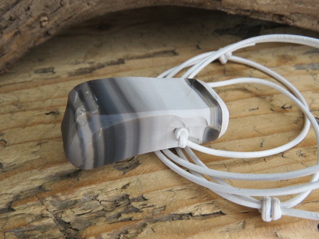 Wisior z krzemienia pasiastego na białym rzemieniu