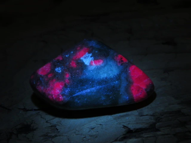 Okaz fuchsytu z rubinami - kamień wypolerowany, luminescencja UV